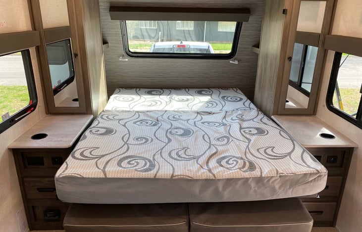 Full sized queen bed with night stands with electric plugs for charging devices. Hanging wardrobes on each side of the bed for hanging clothes, jackets, etc.