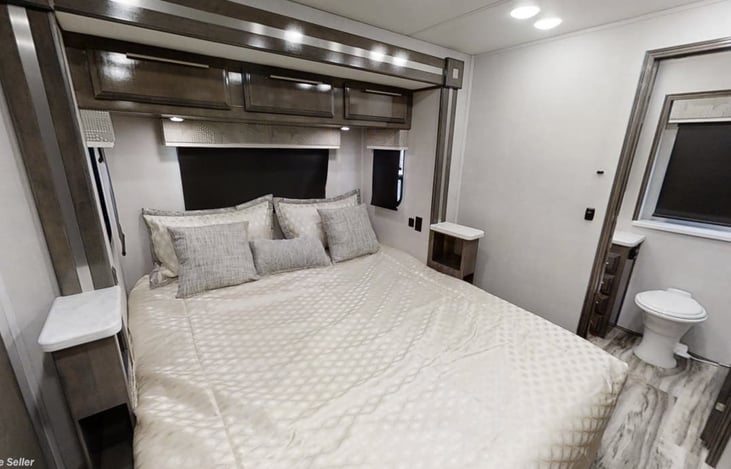 King bed pulled out, with view of primary bathroom.