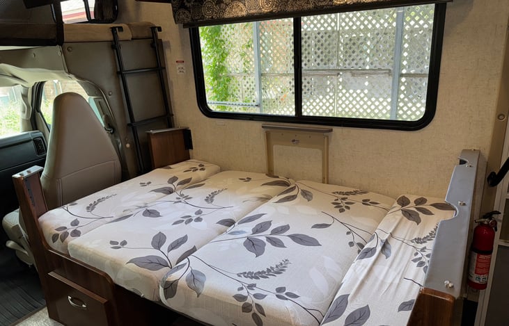 Dinette table easily lowers to convert into a bed approximately 63" long by 40" wide.