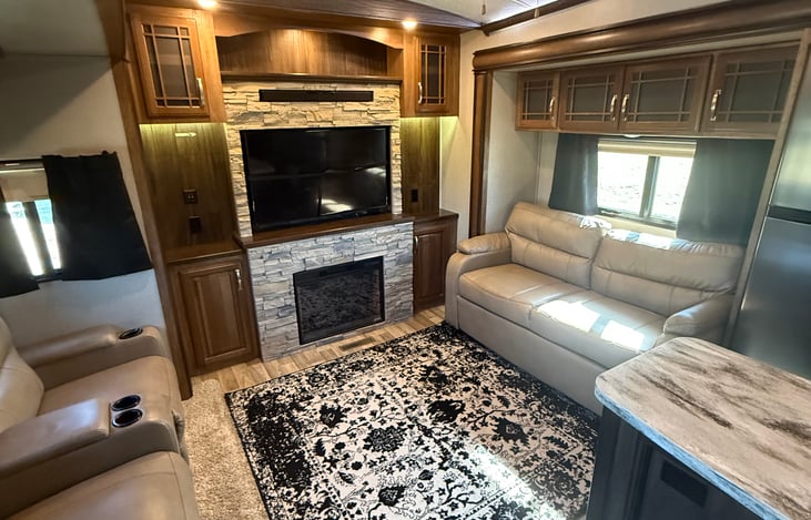 Living room with electric heater/ fireplace and 55" tv with sound bar! Electric recliners.