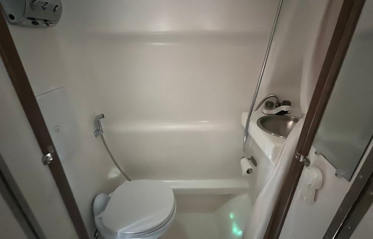 All in one! Toilet, shower, sink. Mirror inside door.