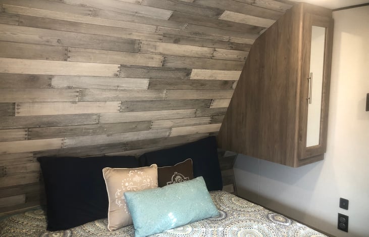 Master Bedroom with walk around Queen size bed with storage underneath and wardrobes and bedside stands on both sides.