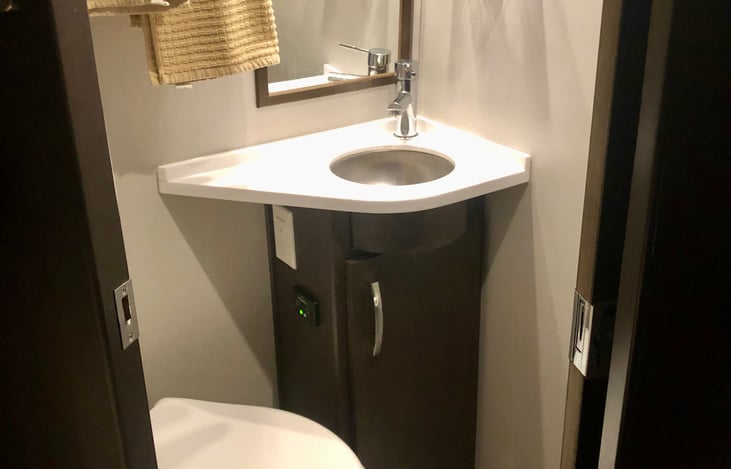 Toilet with sink.
The shower is separate.