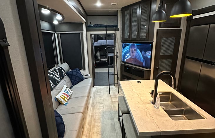 Main area, with kids bunk above door, 4 seat recliner sofa