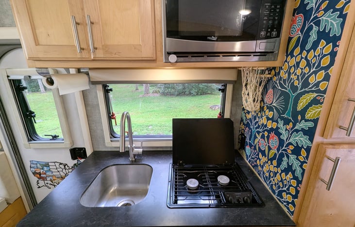 Well-stocked kitchen with two burner stove and a microwave. Enjoy making your meals with a view.