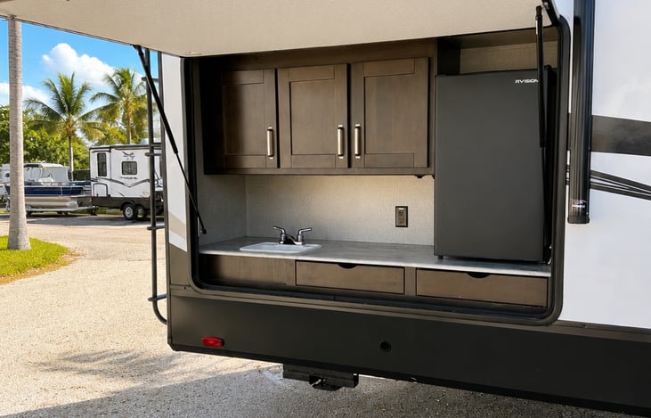 Outdoor kitchen with mini fridge, cook top, and sink