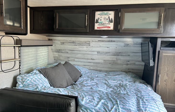 Queen size bed includes linens. TV mounted above bed. Ample storage above bed.