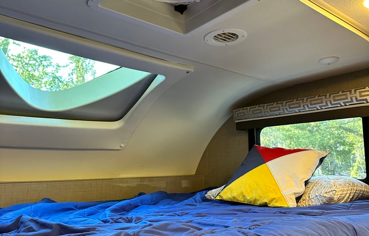Bunk over drivers compartment with skylight. Great for star gazing at night. Great spot for 2 children or one adult comfortably. Has a ladder to access