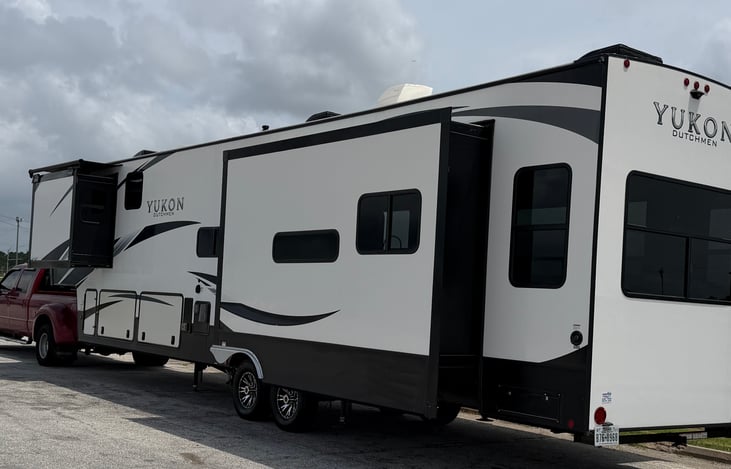 Premium Outdoor Living: Over 42 feet of high-gloss fiberglass elegance featuring dual electric adjustable power awnings with built-in LED lighting.