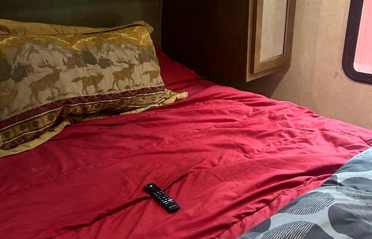 Front short queen new foam mattress with topper. Wardrobe space on either side of bed.  Storage above head of bed.