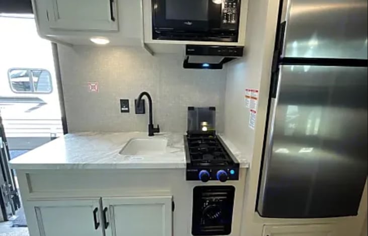 Kitchen with lots of counter space! high rise faucet, microwave oven, 2-burner stove top.