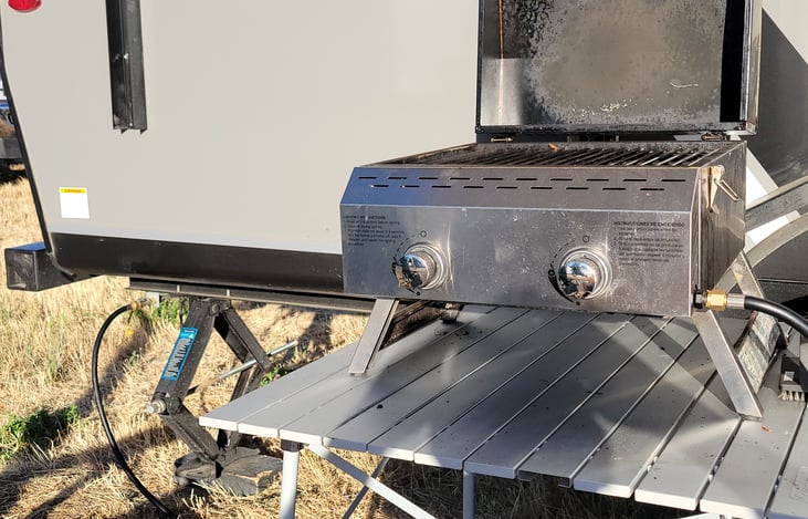 Included outdoor propane grill and metal folding table. Has 6' propane hose to outside tap near back bumper.