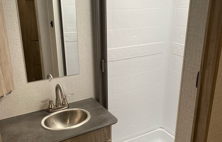 View of Shower and Sink in Bath.  Porcelain toilet also.