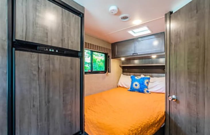 The full-size bed has plenty of overhead storage and lighting!