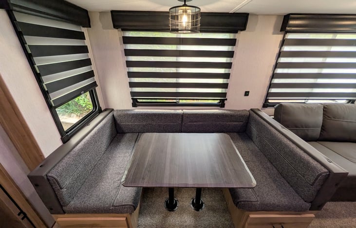 Spacious dinette and cozy couch surrounded by windows both convert to comfy beds.