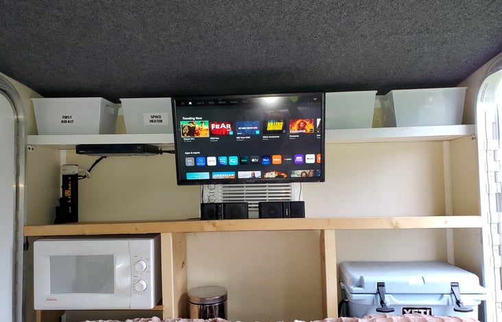 First Aid Kit on top shelf next to temperature control space heater if needed, empty containers for you to organize your things, room to keep shoes inside