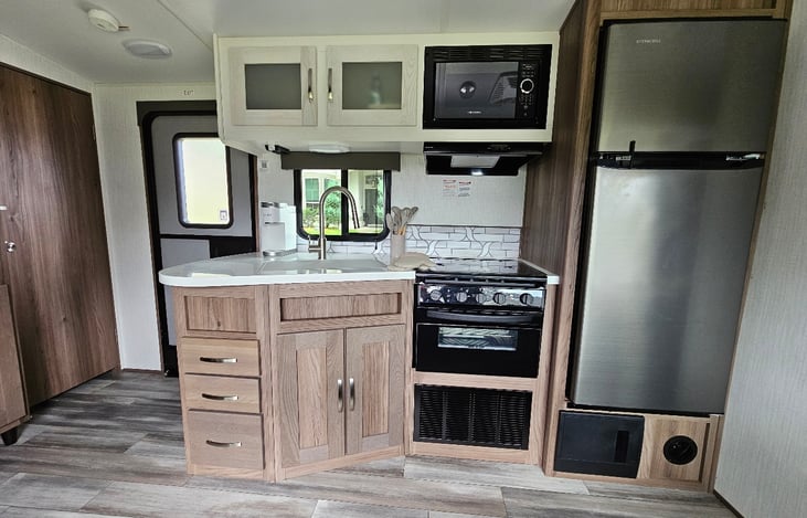 Airfryer oven, three burner gas stove, microwave, large fridge freezer, coffee maker, toaster, pots and pans. also not shown outdoor kitchen with second fridge and grill.