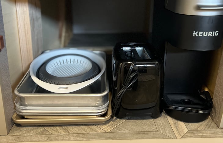 Underneath the dinette is 1 large storage bin for extra kitchen or other storage, and under the other side is your kitchen supplies: Keurig, toaster, collapsible colander, and pans