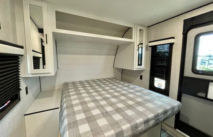 Main bedroom with a queen bed and different cabinets for clothing.