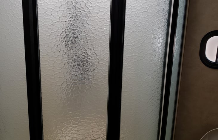 Shower doors in full bathroom.