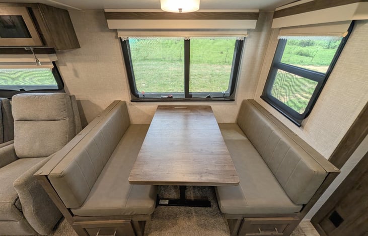 Spacious open-concept living area w/ dual recliners, TV & fireplace. Full kitchen features a residential fridge, 3-burner stove, oven, microwave, deep sink & booth dinette! Natural light throughout.