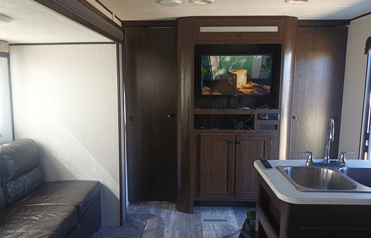 Great room showing kitchen sink, sofa, and TV