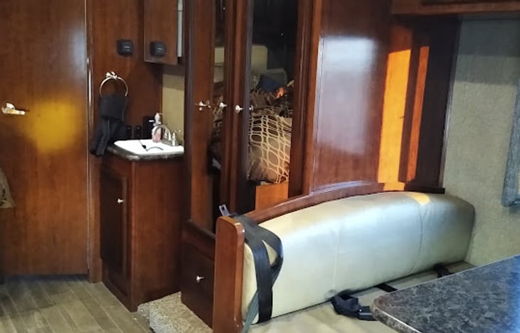 sink and vanity, mirrored vanity, dining table with seatbelts and makes into bed