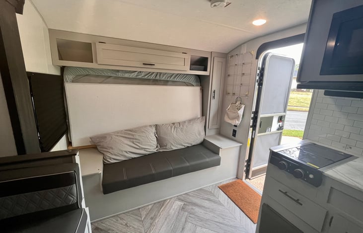 Murphy bed folded into couch. Bed pillows are used for couch cushions to minimize effort and storage needs.