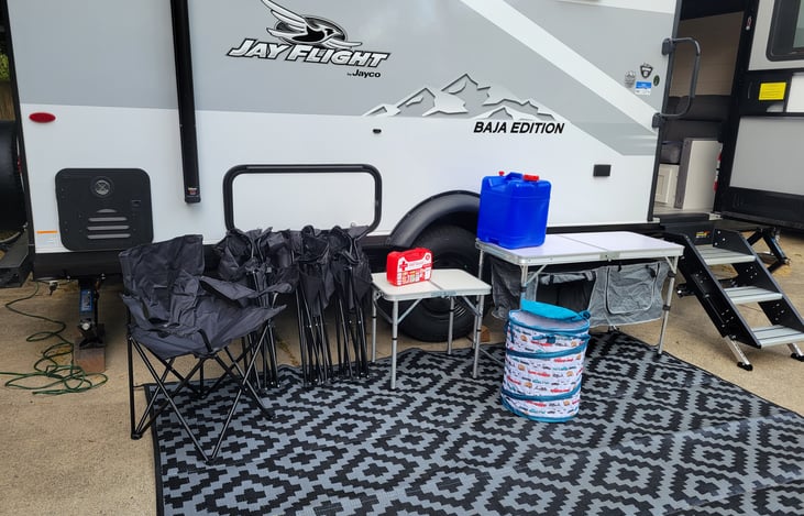 4 chairs, collapsable trash can, tables, first aid kit, and freshwater hauling jug.