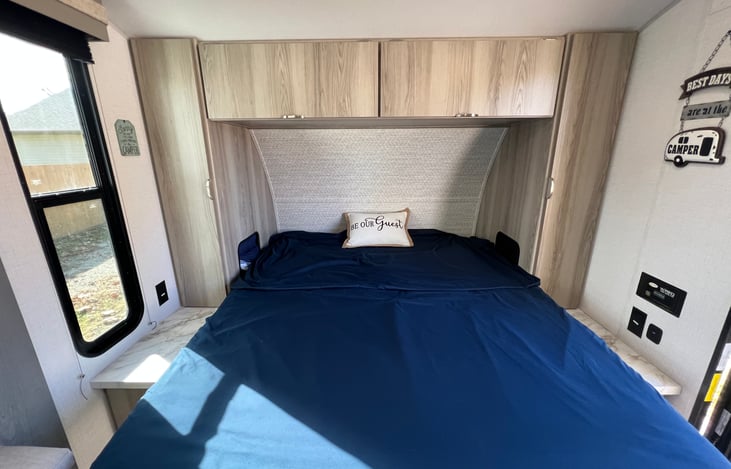RV queen size Murphy bed opened with storage above, below, and beside the bed