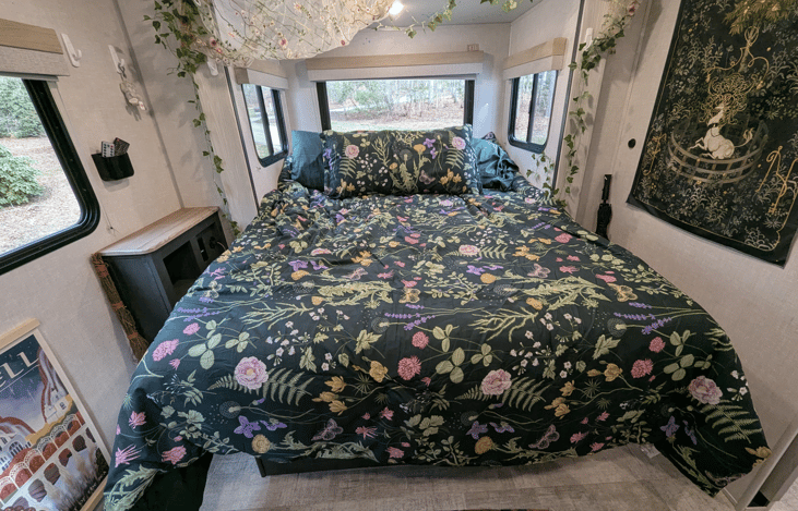 Comfortable, bright, and spacious bedroom slideout with Queen bed, large TV and whimsical touches to make it feel cozy and magical.