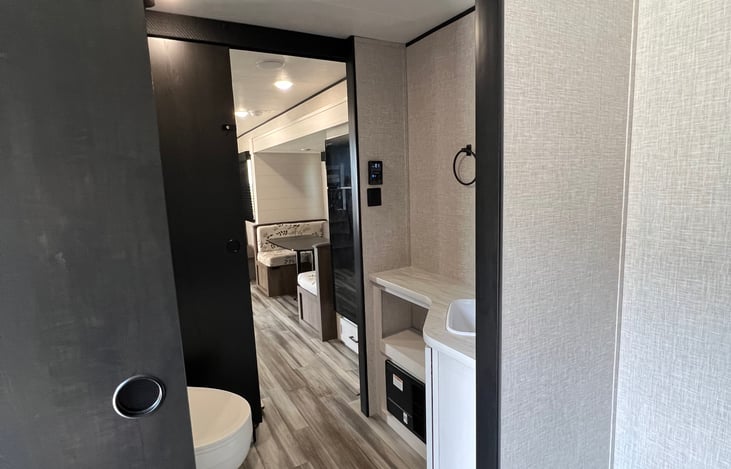 Bathroom separates forward bedroom from common area and bunks