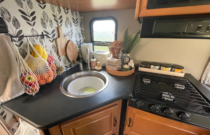 Kitchen space comes with lots, pans, spices, all utensils, plates, cups, bowls, coffee press, 2 gallon water jug, cutting board, picnic blanket, and a selection of teas. All cleaning items included.