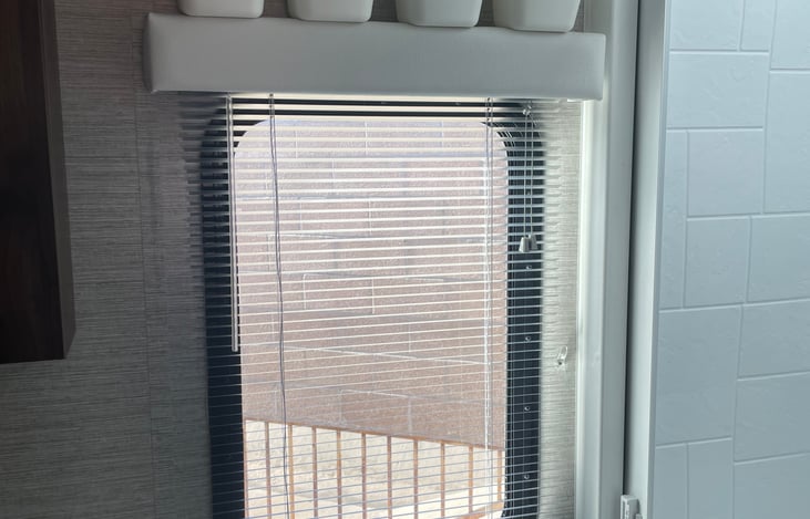 Bathroom window with micro-mini blinds for privacy.  
We have added additional storage above the valance.