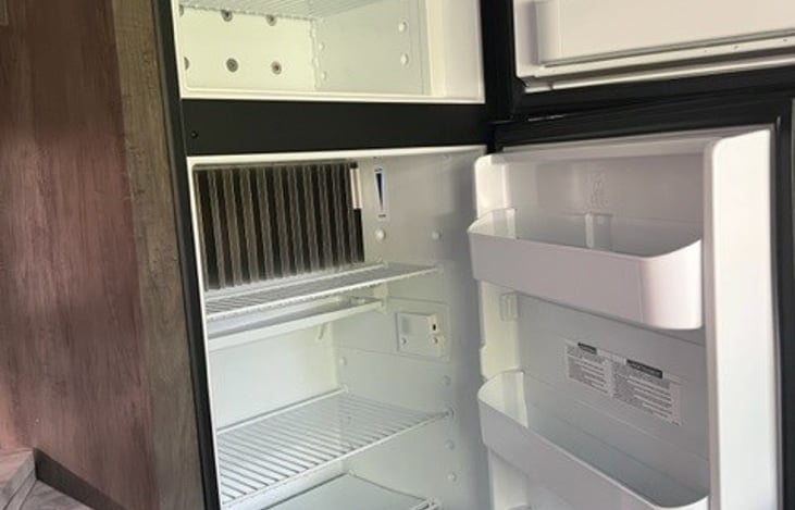Separate freezer/refrigerator compartments with both shelf and door storage, and adjustable temperature settings.