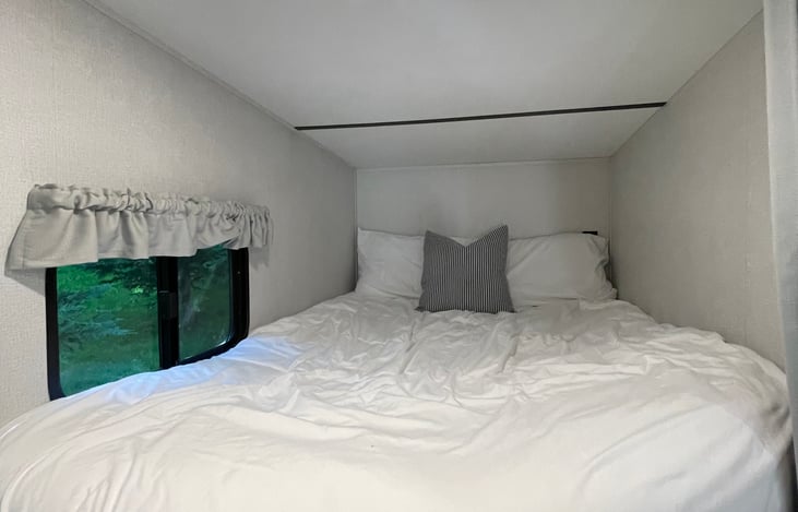 Upper bunk allows for more head space and features its own light, double outlet, and window with blinds. Mattress has a memory foam topper and all linens are included.