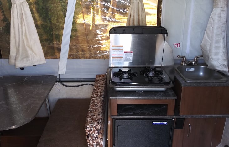 2 burner propane gas stove above refrigerator and next to sink for easy cooking.