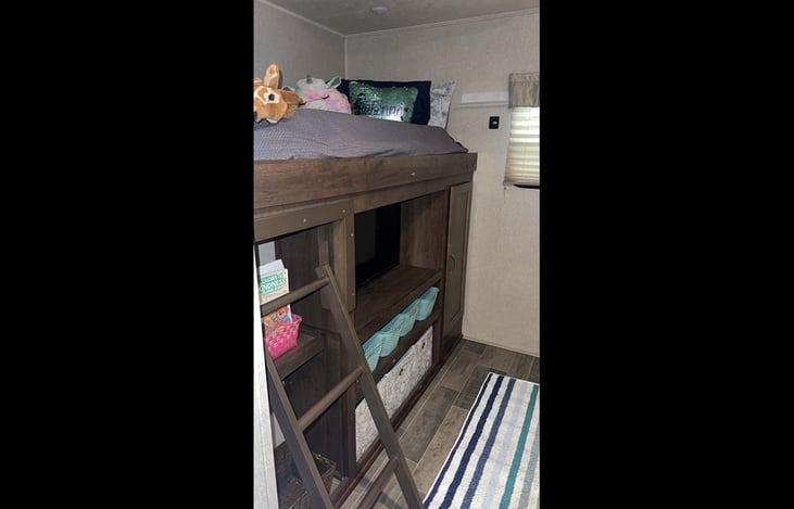 Bunk bed above 32" tv entertainment center and storage.