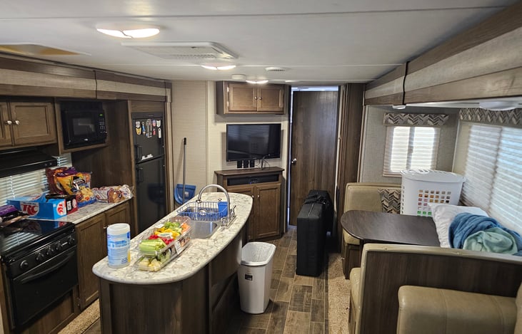 Extra large living area with two slide-outs and an island sink. TV with Roku device. Indoor and outdoor Bluetooth soundbar.