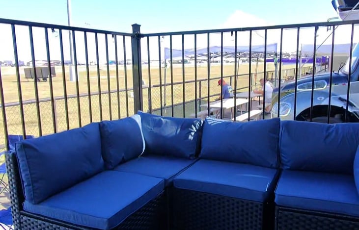 The Hot Tub Suite comes with a fenced in porch w/ an awning, string lights, a couch and a smart TV