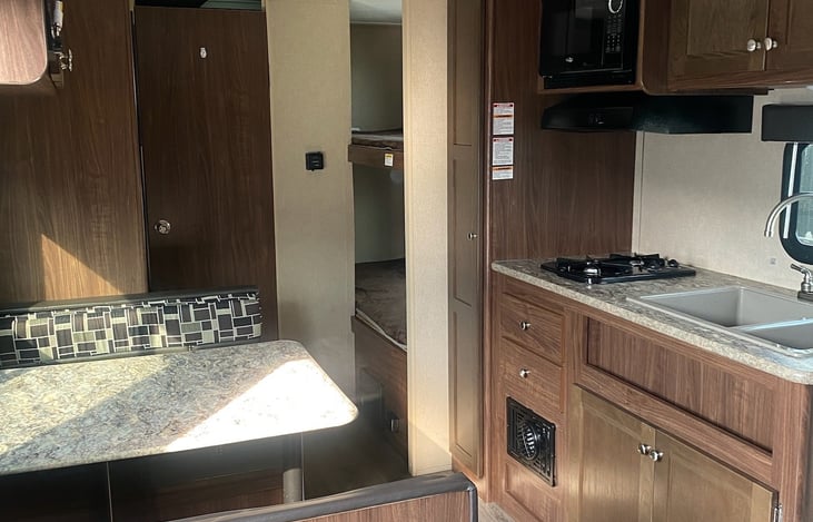 The camper is equipped with stove, microwave and refrigerator.  There is bunk beds in the back of the picture.  Lots of storage room.