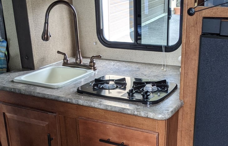 For an RV this size, the kitchen area has lots of counter space behind the sink and stove for things.
