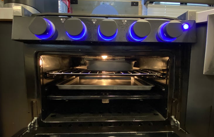 Oven stocked with baking pan, pizza pan and cookie sheet