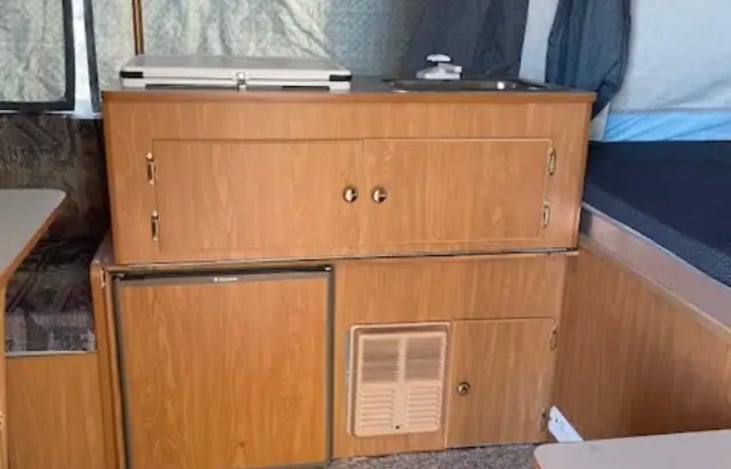 Kitchen sink, 2 burner stove, refrigerator and storage.  Fold over gallery.