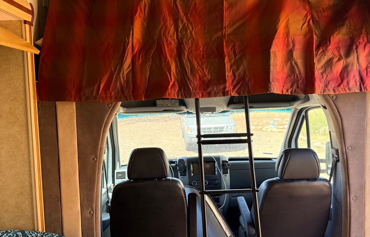 Overhead bunk with privacy curtain—cozy sleeping space with a little extra privacy 🛏️🚐