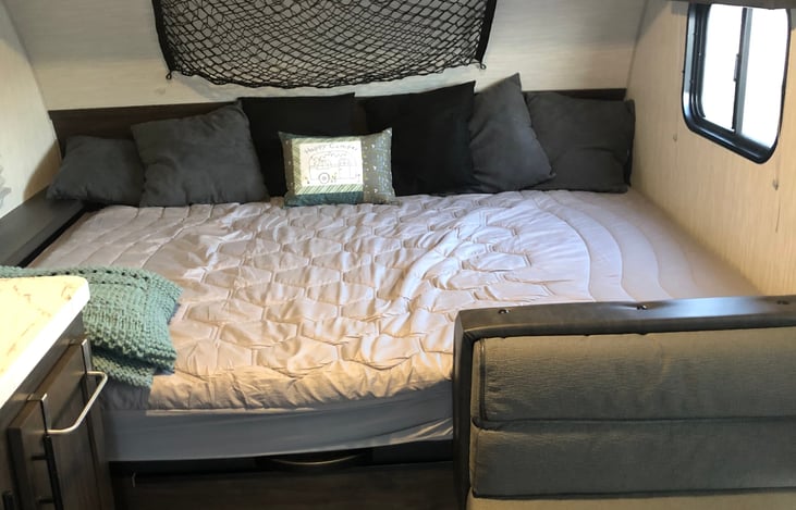 Queen bed in back of trailer.