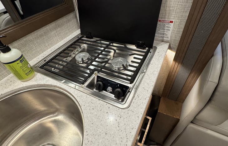 Close up of the stove top, full set of pots and pans provided. Dinner and salad plates, as well as bowls will be stocked as well.