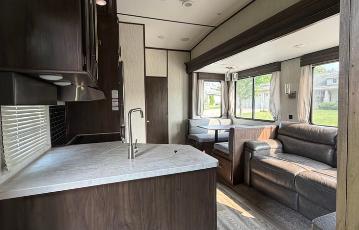 Main living area sink/kitchen, sofa that converts to a full size bed with room. Dining area that also converts to a bed. Oven and 3 burner stove along with fridge and freezer.