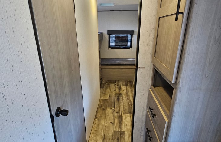 Hallway into private bunkroom. Restroom in door on left with outside access.