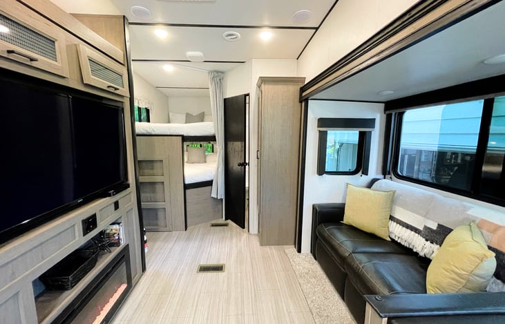 High ceilings and open space make this RV comfortable for multiple people. Full size bunks are just off of the living area next to the bathroom.